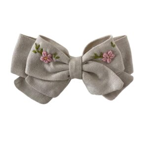 Moño de lino beige bordado a mano en tonos rosa pastel,