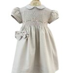 Vestido de ceremonia confeccionado en lino beige con bordado rosa pastel hecho a mano que va de la cintura al hombro